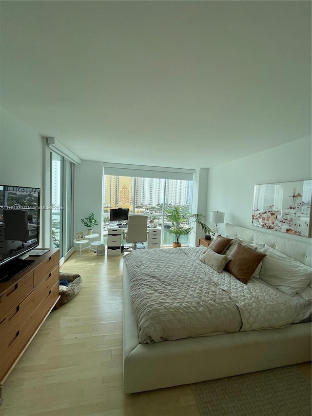 bedroom featuring multiple windows and light hardwood / wood-style floors