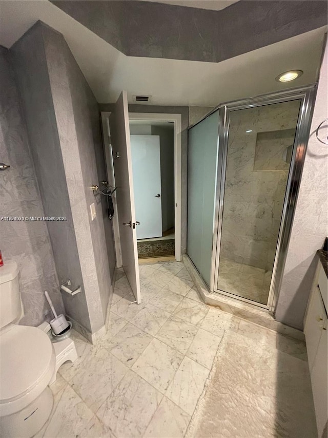 bathroom with an enclosed shower and toilet