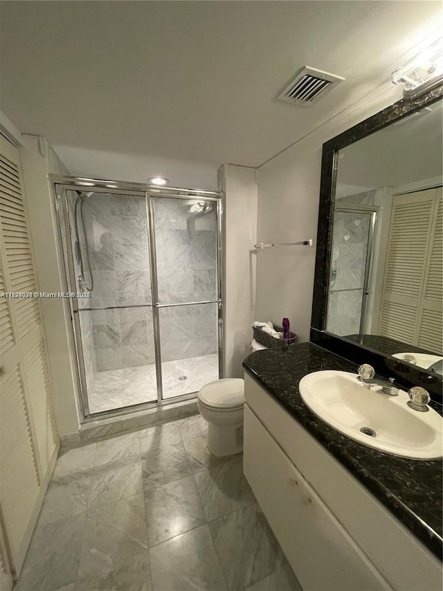 bathroom featuring vanity, an enclosed shower, and toilet