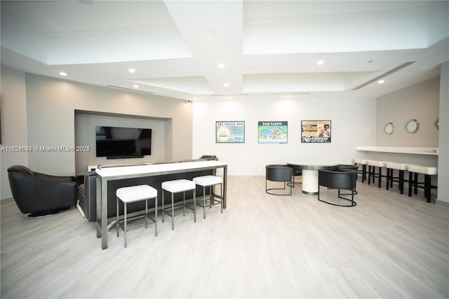 living room featuring a raised ceiling and light hardwood / wood-style flooring