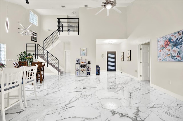 entryway with ceiling fan and a high ceiling