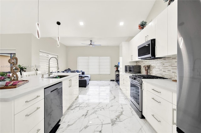 kitchen with white cabinetry, sink, stainless steel appliances, decorative light fixtures, and decorative backsplash