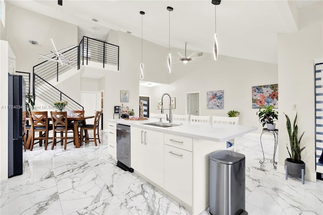 kitchen featuring sink, stainless steel dishwasher, decorative light fixtures, a center island with sink, and white cabinets