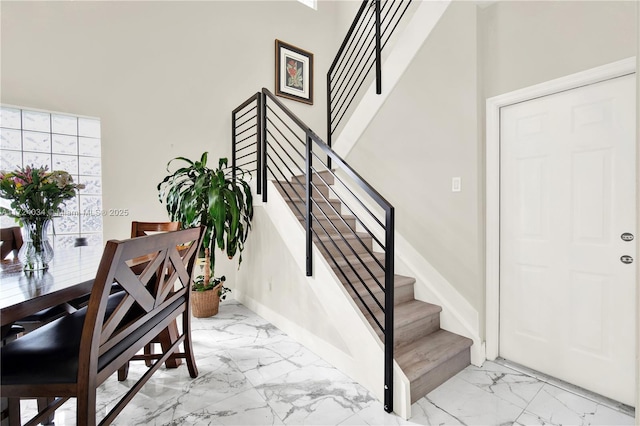 stairway with plenty of natural light and a towering ceiling