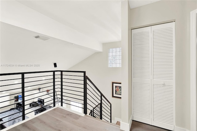 staircase with wood-type flooring and lofted ceiling