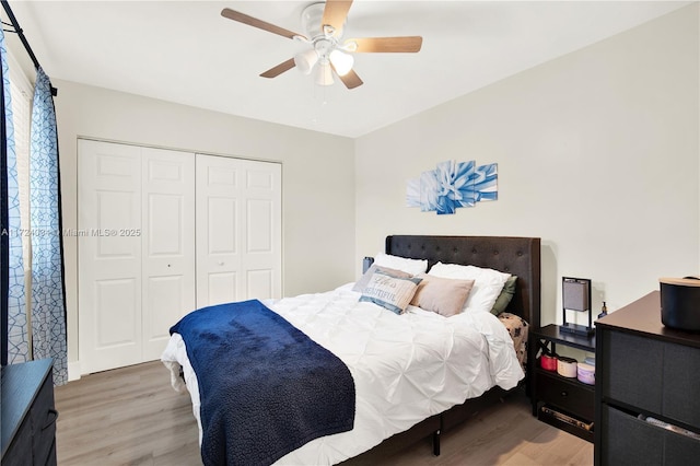 bedroom featuring hardwood / wood-style flooring, ceiling fan, and a closet