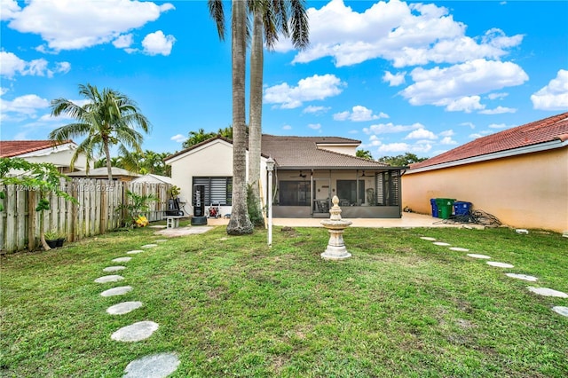 rear view of property featuring a yard, a patio, and a sunroom