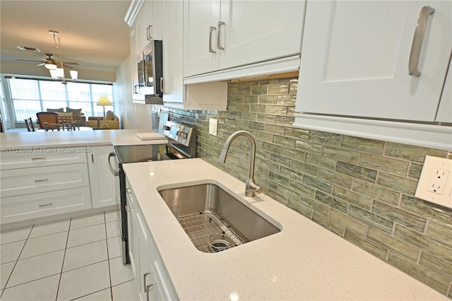 kitchen with white cabinets, sink, decorative backsplash, light stone counters, and stainless steel appliances