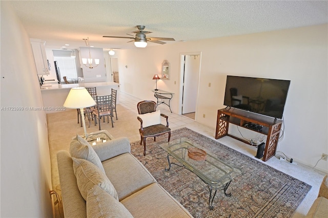 living room featuring ceiling fan with notable chandelier, light tile patterned floors, and a textured ceiling