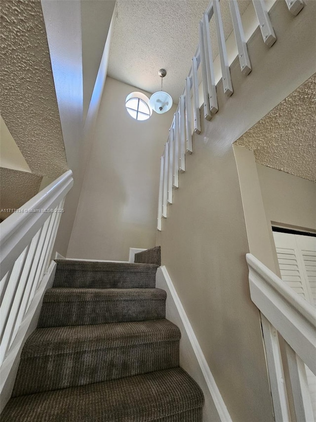 staircase with a textured ceiling