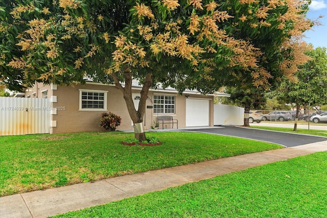 view of front of home with a garage and a front lawn