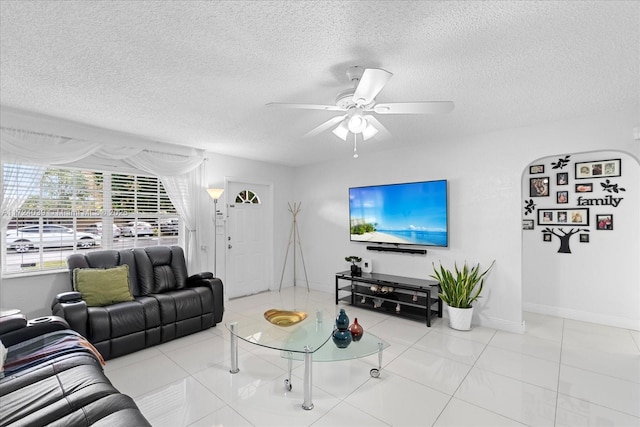 living room with light tile patterned floors, a textured ceiling, and ceiling fan