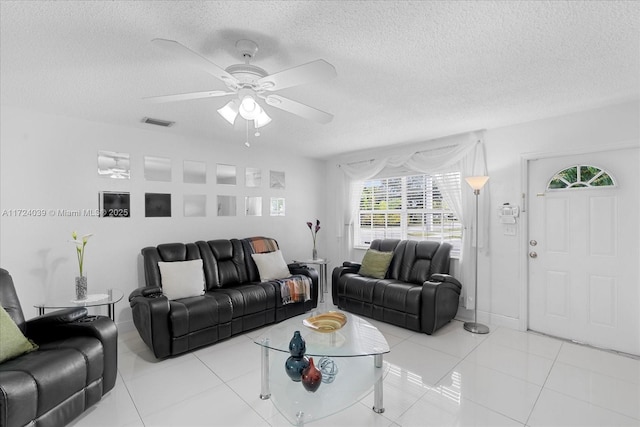 tiled living room with ceiling fan and a textured ceiling