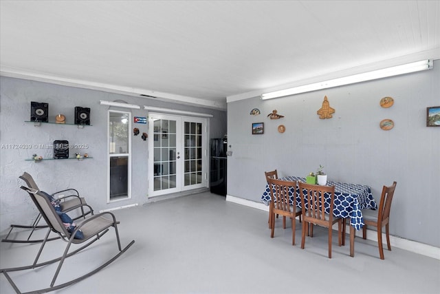 dining space with french doors and concrete floors