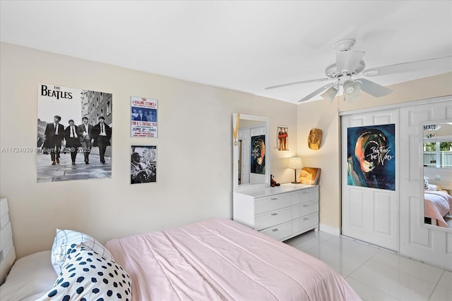 bedroom featuring ceiling fan, light tile patterned flooring, and a closet