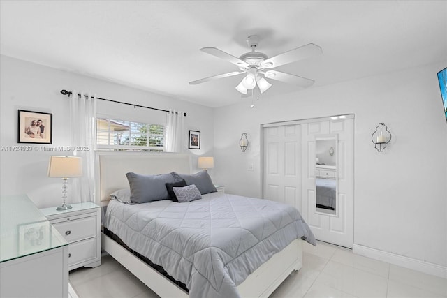 bedroom with light tile patterned floors, a closet, and ceiling fan