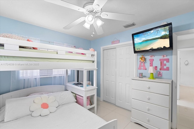 tiled bedroom featuring ceiling fan and a closet