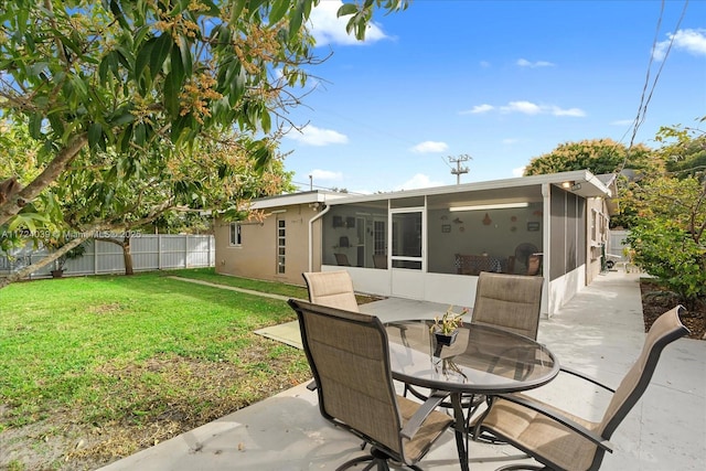 back of property featuring a sunroom, a yard, and a patio