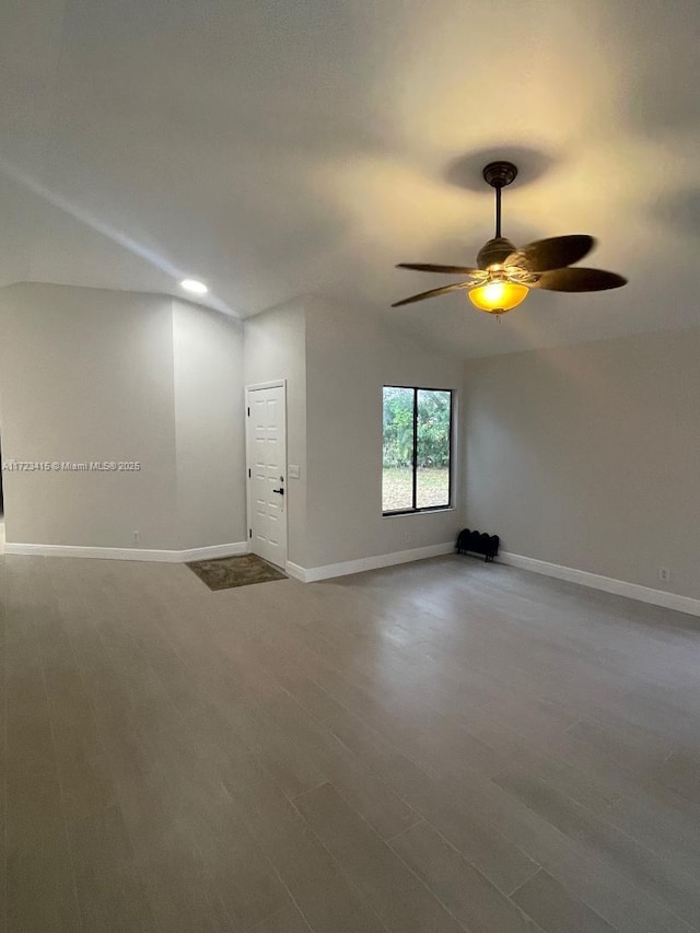 spare room featuring hardwood / wood-style floors, vaulted ceiling, and ceiling fan