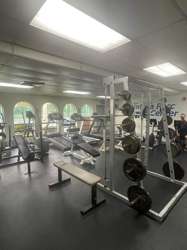 workout area featuring a paneled ceiling and a healthy amount of sunlight