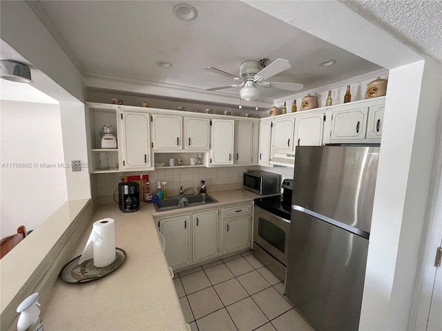 kitchen with sink, stainless steel appliances, light tile patterned floors, tasteful backsplash, and white cabinets