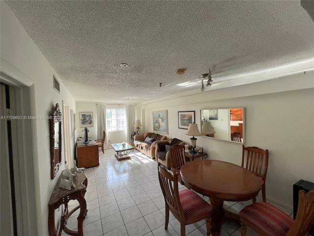 dining area with light tile patterned floors and a textured ceiling