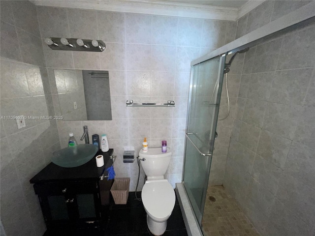 bathroom with vanity, toilet, ornamental molding, walk in shower, and tile walls