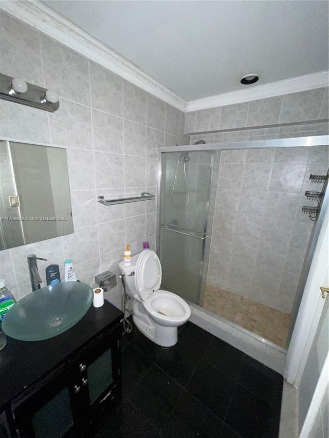 bathroom with vanity, crown molding, toilet, tile walls, and an enclosed shower