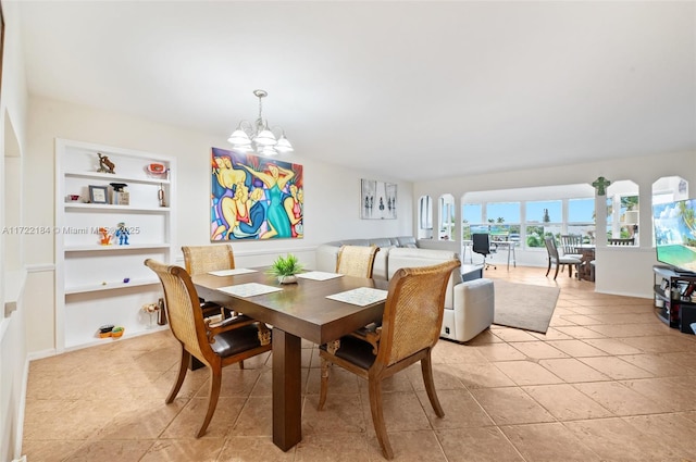 dining space featuring built in shelves, light tile patterned flooring, and a chandelier