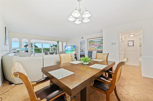 tiled dining space featuring an inviting chandelier