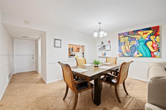 dining room featuring built in shelves and an inviting chandelier