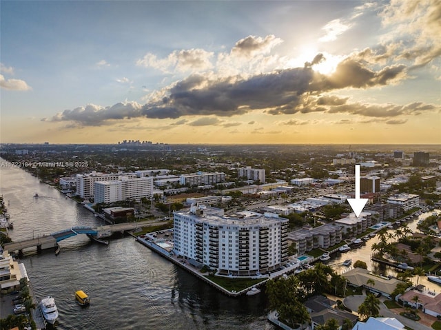 aerial view at dusk featuring a water view