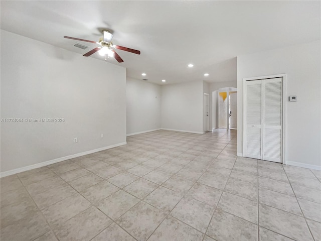 tiled spare room with ceiling fan