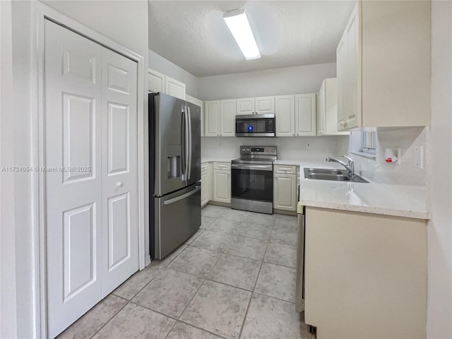 kitchen featuring white cabinetry, light tile patterned floors, sink, and appliances with stainless steel finishes