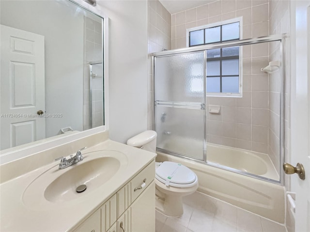 full bathroom with tile patterned flooring, vanity, bath / shower combo with glass door, and toilet