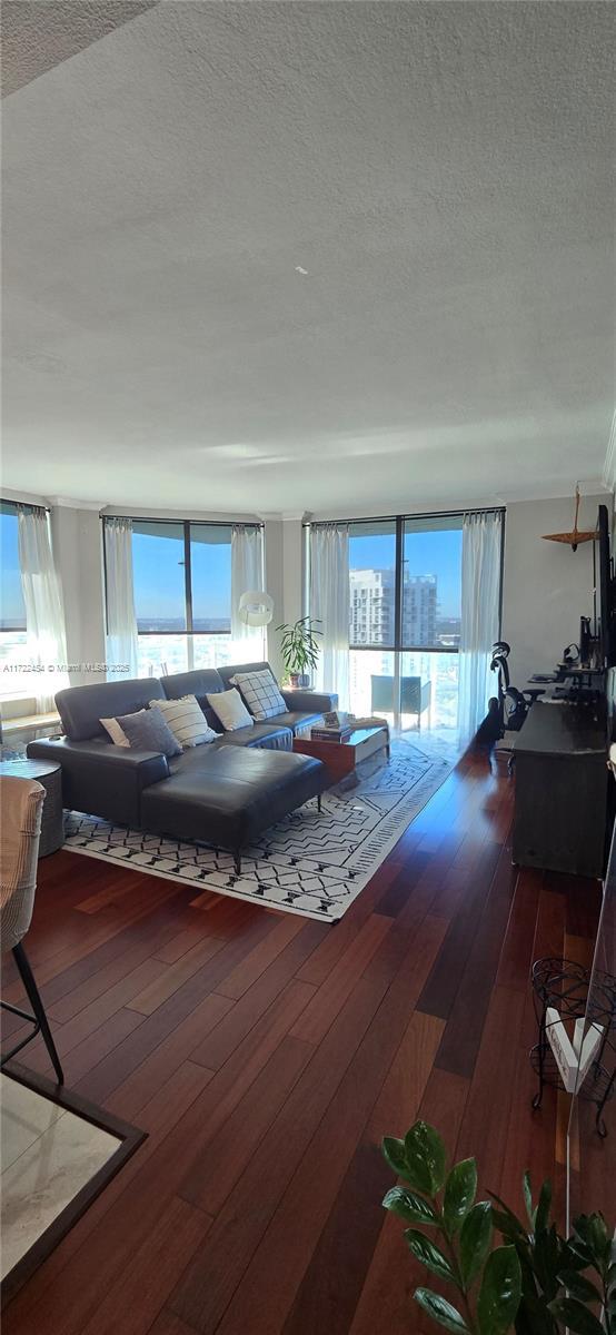 living room with hardwood / wood-style flooring, a wealth of natural light, and a textured ceiling