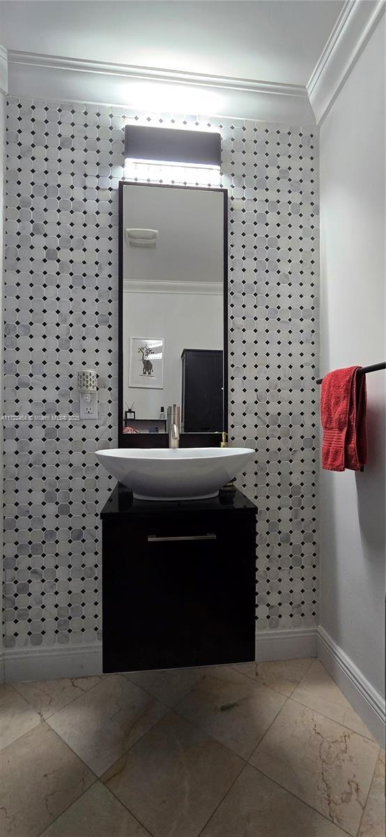 bathroom with vanity and ornamental molding