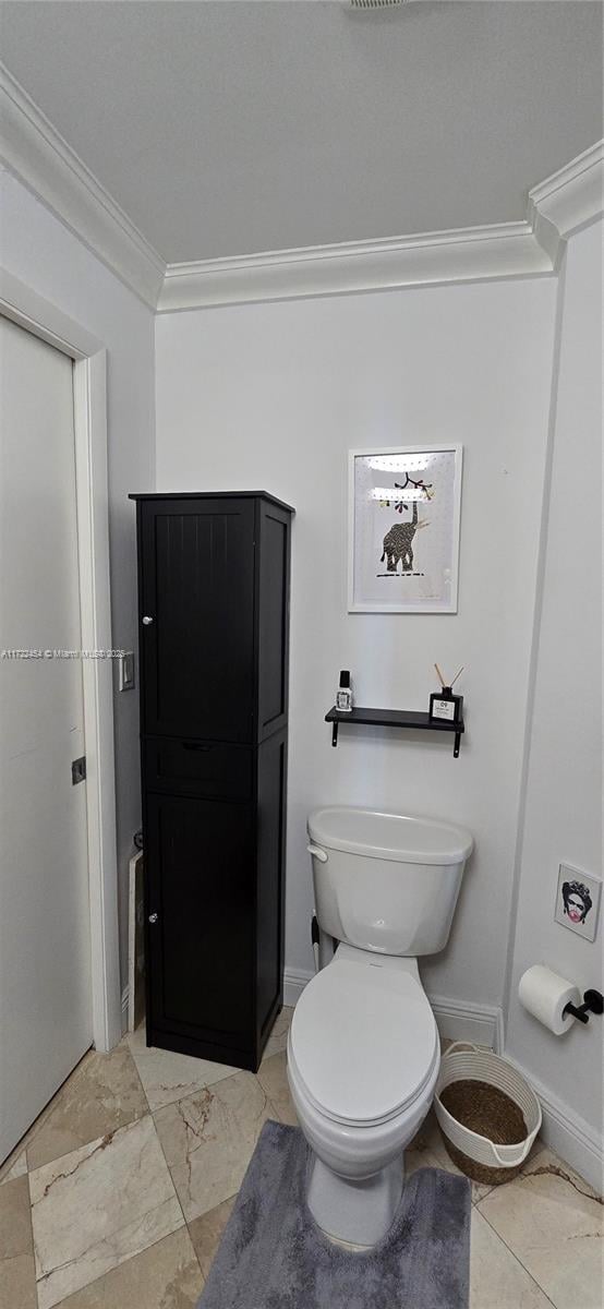 bathroom with ornamental molding and toilet