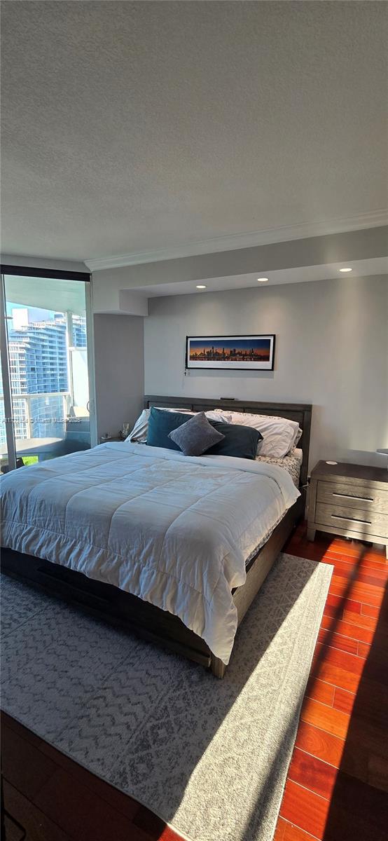 bedroom featuring hardwood / wood-style flooring and a textured ceiling