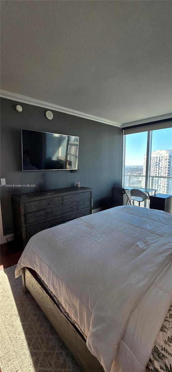 bedroom with ornamental molding and a textured ceiling