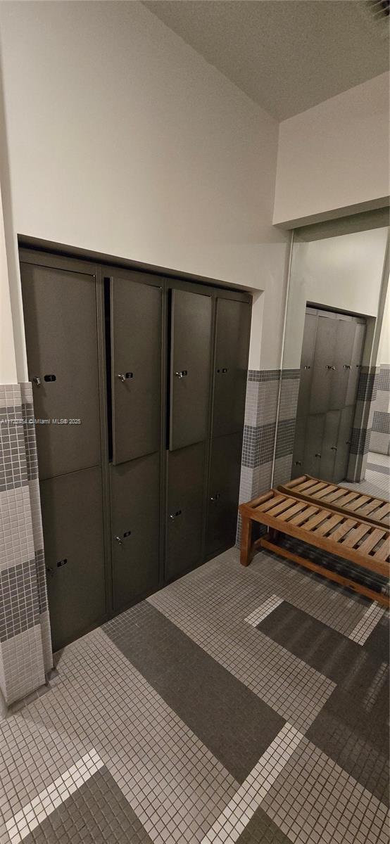 bedroom featuring tile patterned flooring, a closet, and a mail area