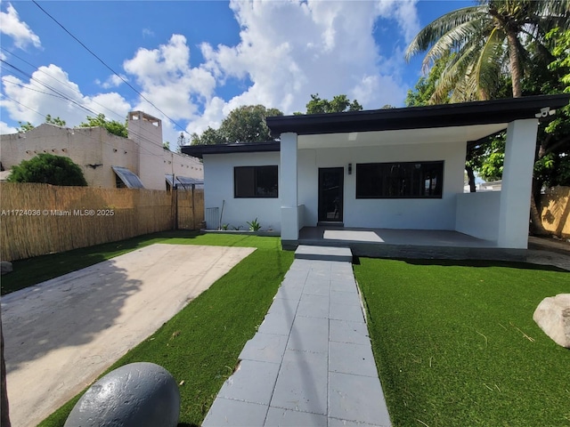 view of front of home featuring a patio and a front lawn