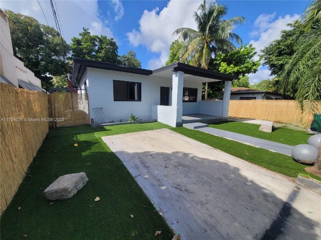 view of front facade with a front lawn and a patio area