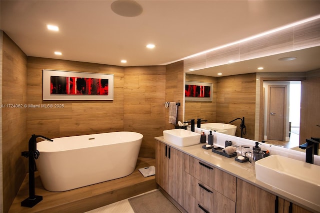 bathroom featuring a tub to relax in, hardwood / wood-style floors, and vanity