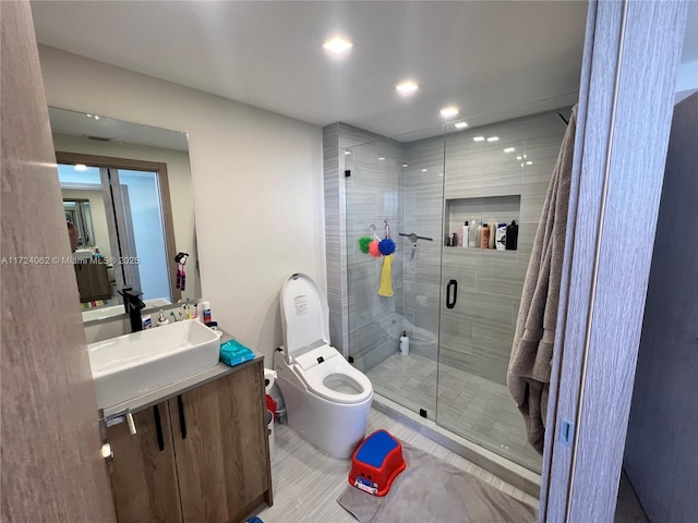 bathroom featuring vanity, toilet, and a shower with shower door