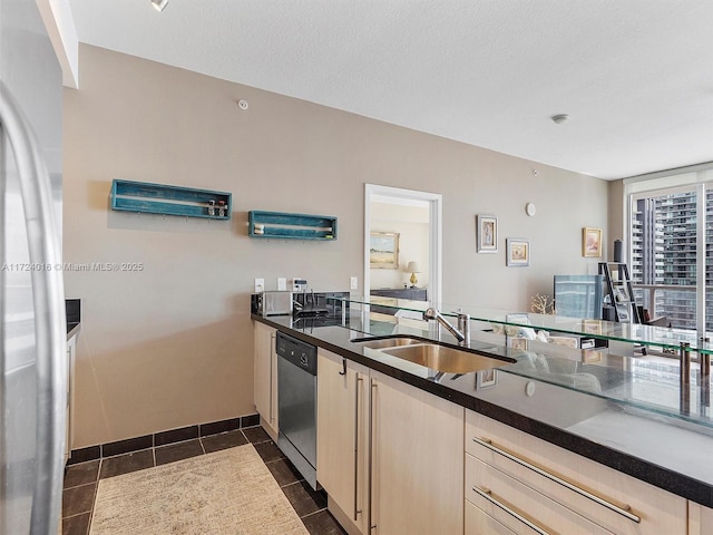 kitchen with sink, dark tile patterned floors, stainless steel appliances, and light brown cabinets