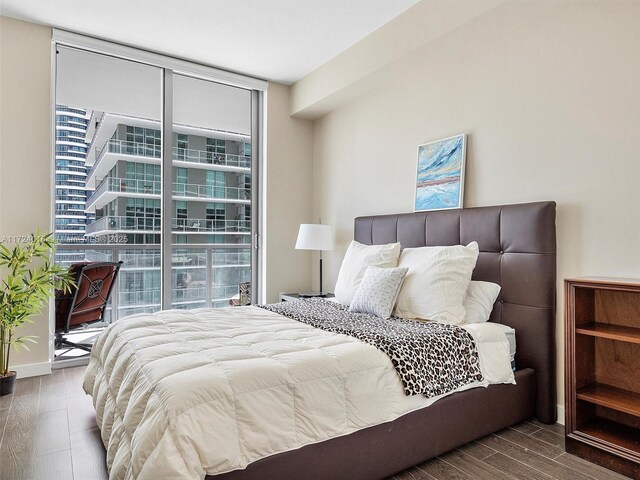 bedroom featuring expansive windows and hardwood / wood-style flooring