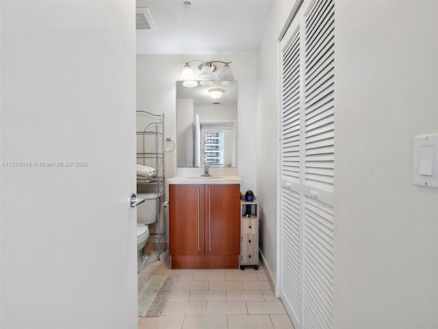 bathroom featuring tile patterned floors, vanity, and toilet