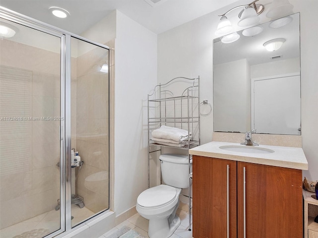 bathroom featuring tile patterned floors, vanity, toilet, and a shower with door