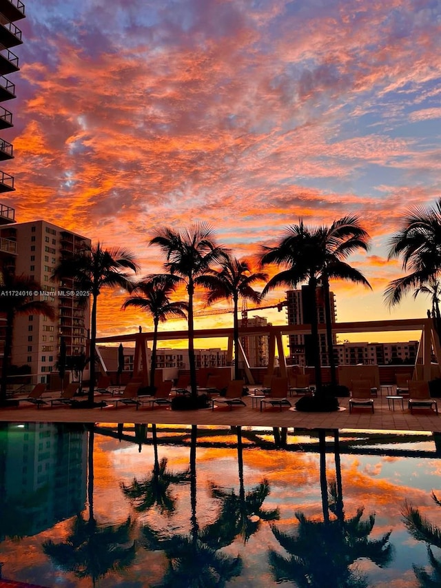 pool at dusk featuring a water view